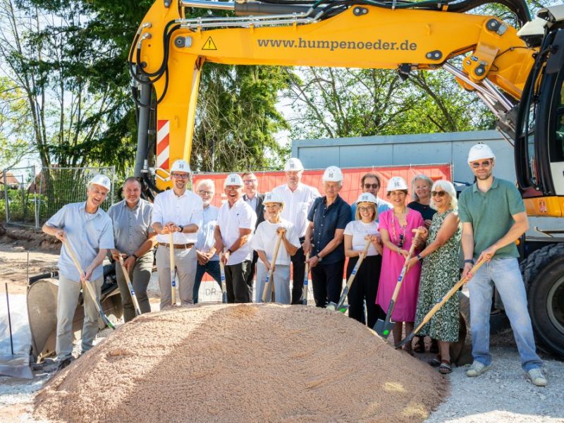 Spatenstich mit Sandhaufen und Bagger