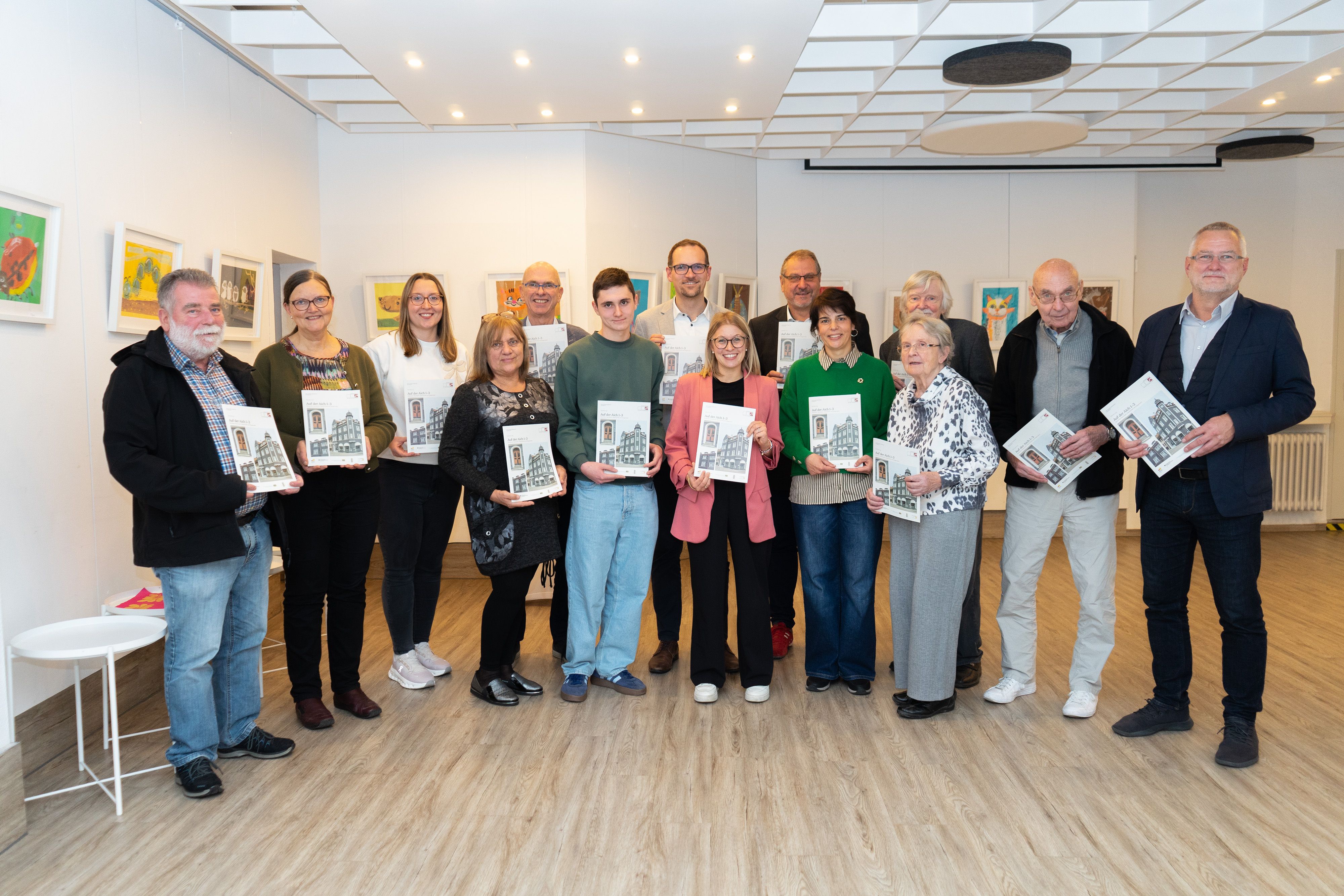 Gruppenbild mit Projektbeteiligten, Zeitzeugen und Gästen aus Stadtverwaltung und Aufsichtsrat: Die GEWOBAU hat ihre mittlerweile 9. Sanierungsbroschüre der Reihe „Dokumentation Baudenkmal Schwabach“ vorgestellt, diesmal sogar in ebenjenem denkmalsanierten Gebäude, Auf der Aich 1 – 3, im Erdgeschoss, wo heute das Haus der Begegnungen untergebracht ist.